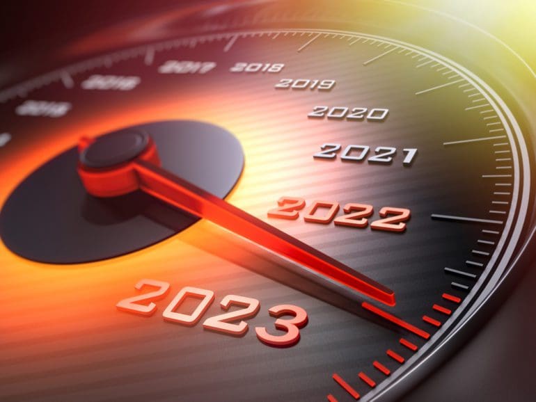 Dark stylish speedometer with orange light and needle moving to the year 2023
